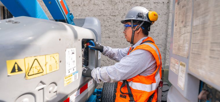 Técnico inspeccionando los controles de una plataforma elevadora articulada