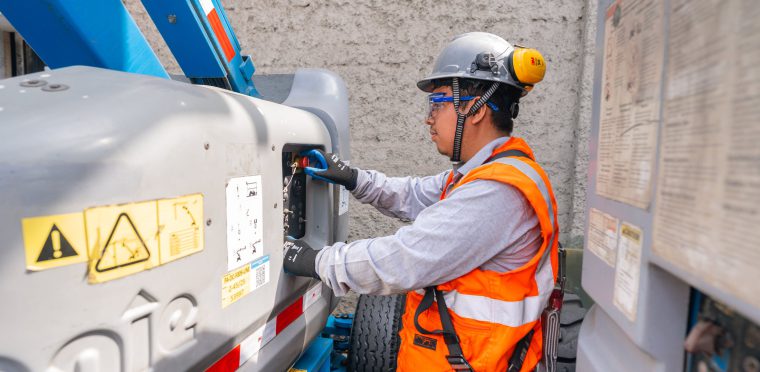 Técnico inspeccionando los controles de una plataforma elevadora articulada